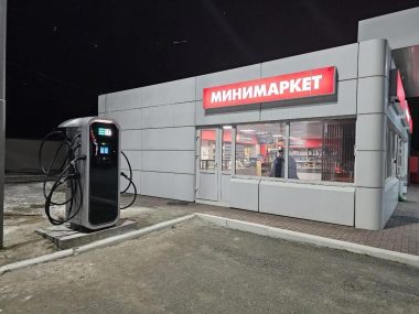 Зарядная станция Elli с подсветкой в тёмное время суток у минимаркета АЗС