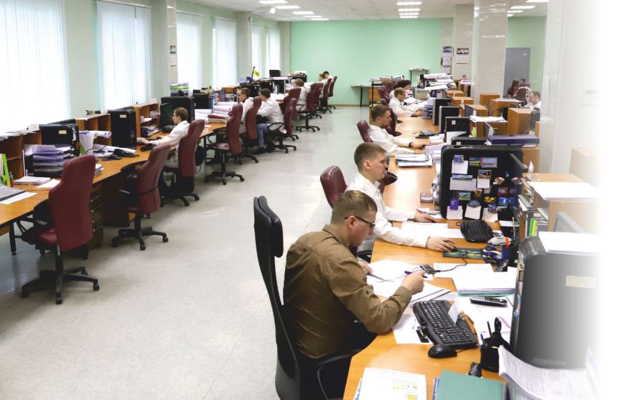 Инженеры конструкторского бюро завода за рабочими местами